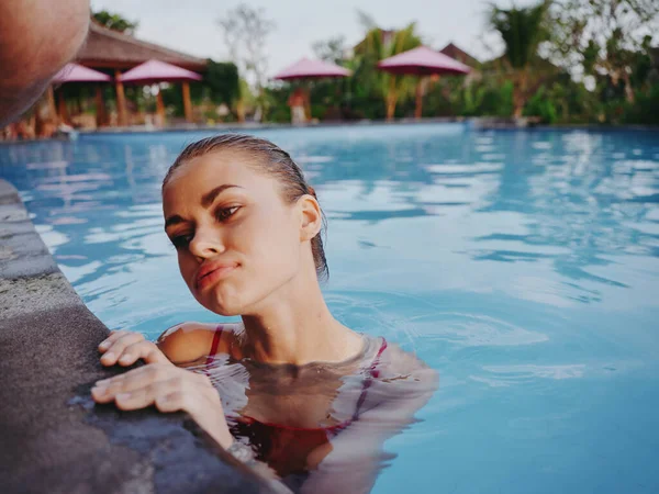 Donna interessata appoggiata sulle piastrelle della piscina e acqua limpida vacanza paesaggio relax — Foto Stock
