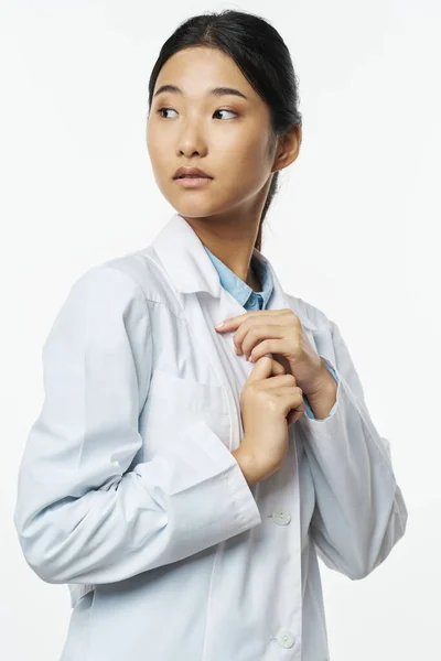 Woman in medical gown brunette light background cropped view asian doctor — Stock fotografie