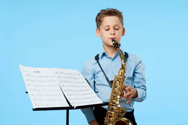 boy musician saxophone training performance blue background