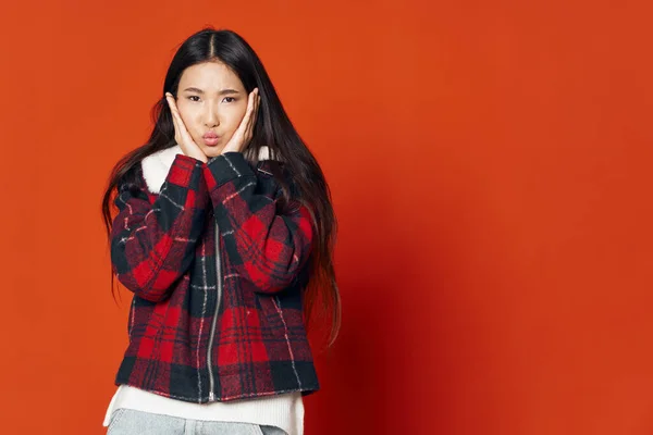 Mujer asiático apariencia invierno chaqueta moda emociones rojo fondo — Foto de Stock