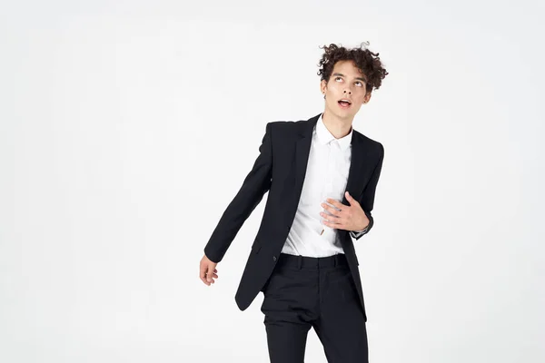 Junger Kerl in einem klassischen Anzug auf einem hellen Hintergrund lockiges Haar Portrait abgeschnitten Ansicht — Stockfoto
