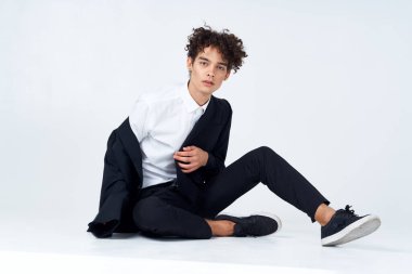 Takım elbiseli bir iş adamı yerde oturmuş kendine güveni tamdır.