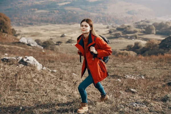 Un viajero en una chaqueta vaqueros y botas sube las montañas en el paisaje de la naturaleza —  Fotos de Stock