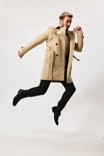 Man in coat autumn style movement emotions light background — Stock Photo, Image