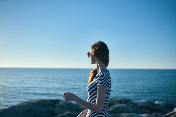 Turismo viaggi montagne paesaggio donna sulla spiaggia vicino al tramonto del mare — Foto Stock