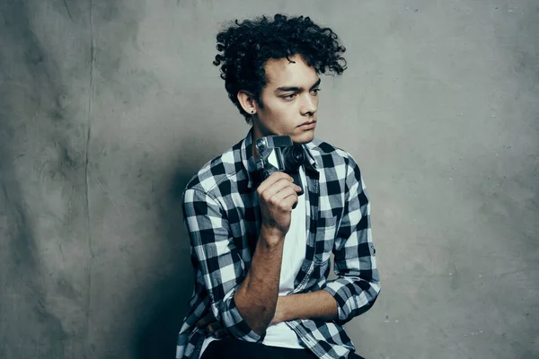 handsome male model in a shirt and a t-shirt on a gray background curly hair hairstyle camera Studio