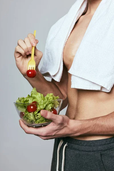 Un uomo con un asciugamano bianco sulle spalle che tiene un piatto di dieta salutare per insalate — Foto Stock