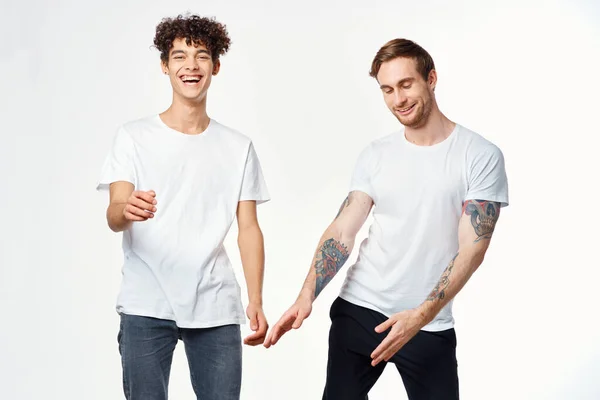 Dos amigos divertidos en camisetas blancas riendo emociones positivas — Foto de Stock