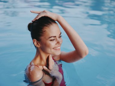 Mayo giymiş neşeli, güzel bir kadın elini başının üstüne koyup dinlensin.