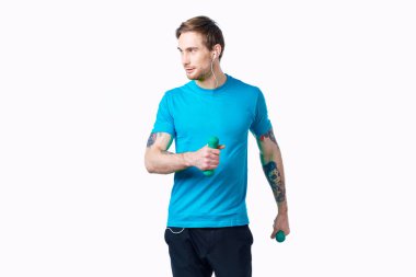 Elinde dambıl, elinde kulaklık, spor salonu olan bir adam.