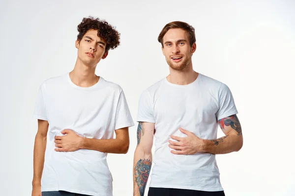 Emotivo due amici in t-shirt bianche sì divertente studio — Foto Stock