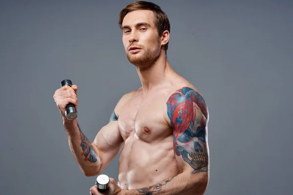 Σέξι αθλητής με φουσκωμένους μυς των χεριών και βιταμίνες για την υγεία μοντέλο αλτήρες — Φωτογραφία Αρχείου