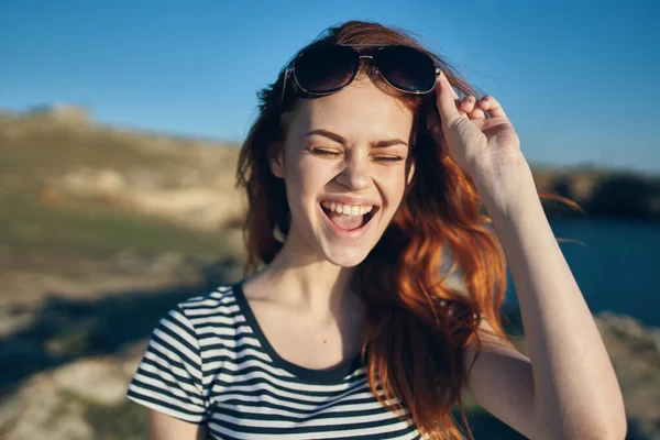 Vrolijk vrouw dragen zonnebril bergen buiten in de buurt van de zee — Stockfoto