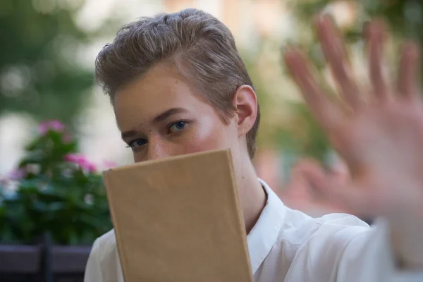 Эмоциональная женщина с книгой в руке белая рубашка портрет модели обрезанный вид — стоковое фото