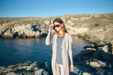 Kızıl saçlı kadın nehir kenarındaki dağlarda dolaşır.