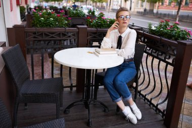 Kafedeki bir masada kısa saçlı bir kadın ve fen bilgisi öğrencisi.