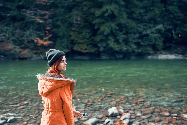 Vrouw in een geel jasje bij de rivier bergen natuur wandeling — Stockfoto