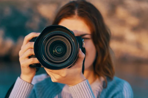 Roodharige vrouw met een camera op de natuur in de bergen bij de rivier — Stockfoto