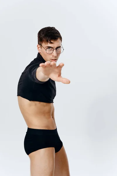 Fisiculturista fitness homem esporte posando em um fundo leve e óculos no rosto do modelo — Fotografia de Stock