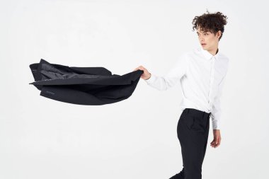  Gömlekli ve pantolonlu bir adam elinde ceket, arka planda kırpılmış bir model.