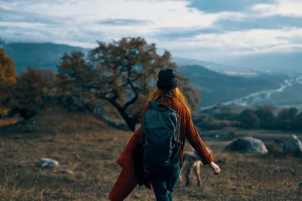 Kobieta turysta z plecakiem na przyrodzie krajobraz pies — Zdjęcie stockowe