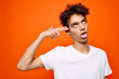 Kıvırcık saçlı adam el hareketleriyle modern duygularını sergiliyor.