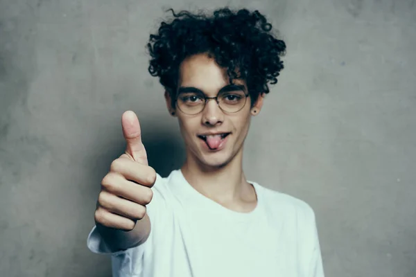 Allegro ragazzo carino con i capelli ricci mostra pollice su emozioni — Foto Stock