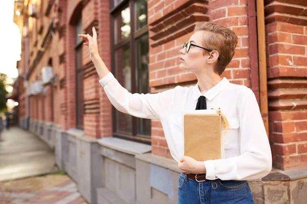 Žena čtení knihy na ulici v blízkosti cihlové budovy a notebook vzdělávání student vědy — Stock fotografie