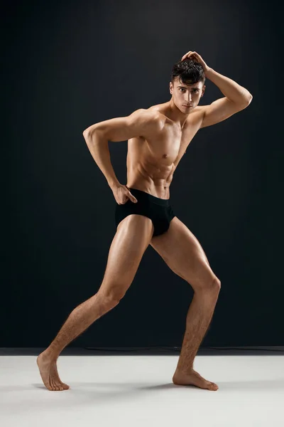Desportivo homem no preto shorts posando no escuro macho fundo — Fotografia de Stock