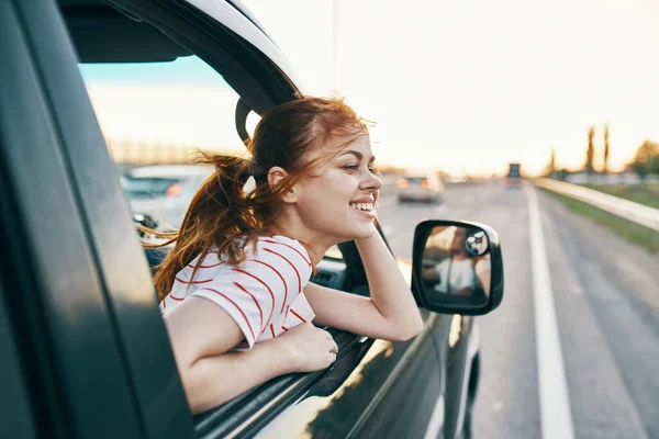 Mujer feliz en la pista asomándose por la ventana del coche en vacaciones de verano y turismo de viajes — Foto de Stock