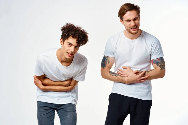 Dos hombres con camisetas blancas están de pie junto a las emociones de amistad — Foto de Stock