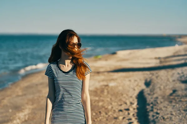 Un viaggiatore in t-shirt a righe riposa sulla spiaggia vicino al mare in estate in montagna — Foto Stock