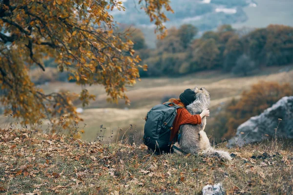 Woman hiker hugging with dog on nature in the mountains travel friendship — Stock Photo, Image