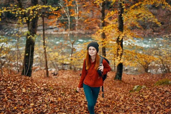 Reizen toerisme vrouw in trui en jeans in de herfst bos in de buurt van berg rivier — Stockfoto