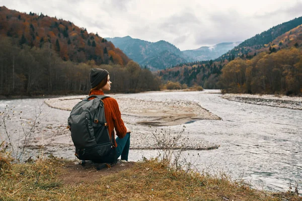 Femme voyage dans les montagnes près de la rivière dans la nature et regarde les montagnes au loin — Photo