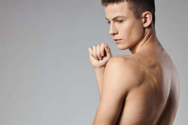 Sırtı çıplak, kasları şişmiş atlet arka plan gri vücut geliştirici Boşluğu Kopyala