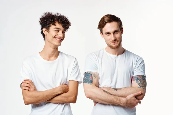 Dos hombres en camisetas blancas de pie lado a lado recortado ver estudio amistad — Foto de Stock