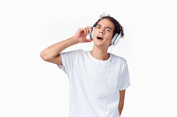 Mężczyzna z kręconymi włosami słuchanie muzyki ze słuchawkami nastolatek moda nowa technologia t koszula — Zdjęcie stockowe