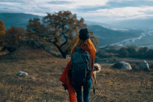 Kobieta turysta z plecakiem na przyrodzie krajobraz pies — Zdjęcie stockowe