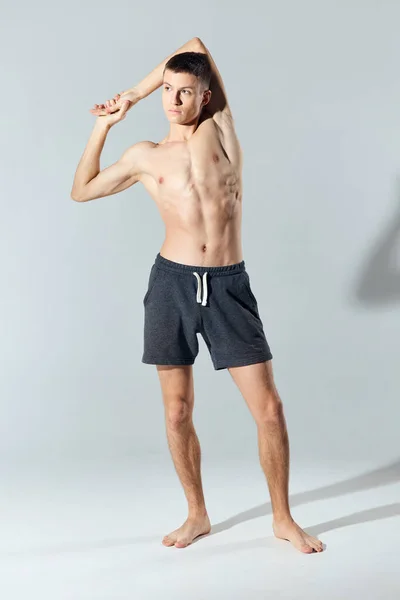 Athlete in shorts with a naked torso joined hands behind the head — Stock Photo, Image