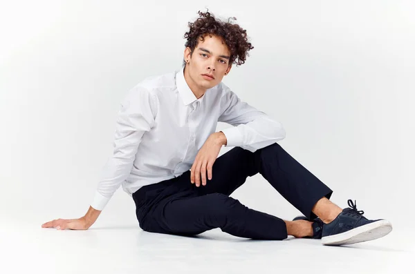 Tiener in sneakers, zwarte broek en een wit shirt in een heldere kamer in volle groei — Stockfoto