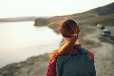 Sırt çantasında sırt çantası olan güzel bir kadın gülümsüyor turizm deniz doğası