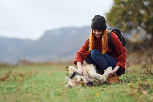 3.带背包的女徒步旅行者在野外玩耍时总是带着狗的天性 — 图库照片