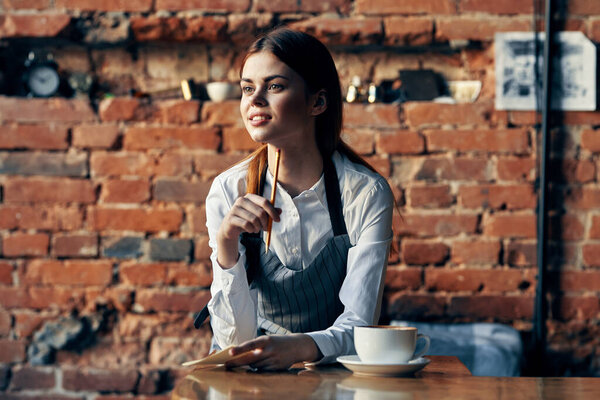 woman waiter in cafe uniform near the table