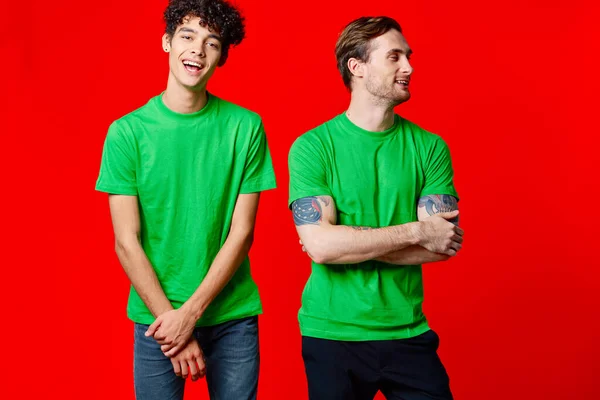 Zwei Freunde in grünen T-Shirts kommunizieren Freundschaft positiv — Stockfoto