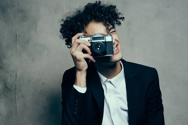 Photographer with a camera in a classic suit curly hair Studio Model — Stock Photo, Image