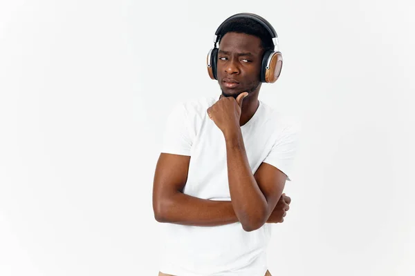 Un hombre con una expresión satisfecha en su cara en auriculares escucha música — Foto de Stock