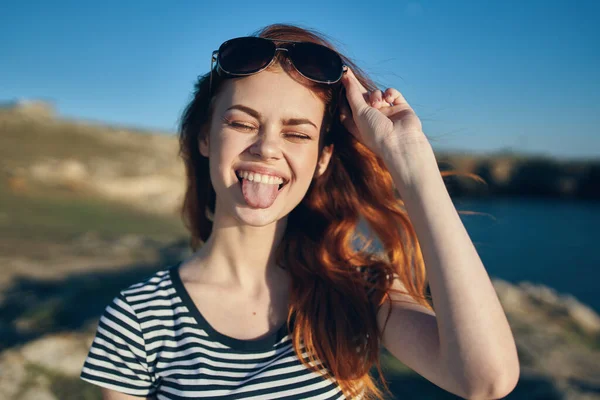 cheerful woman wearing sunglasses mountains outdoors near the sea