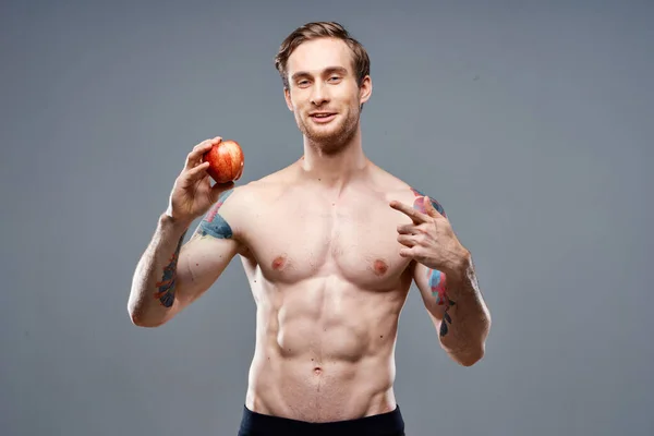 Homem com maçã e esporte comida saudável bombeado acima do fisiculturista bolo — Fotografia de Stock