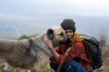 Kadın turist köpek kucaklıyor doğa seyahat arkadaşlığı